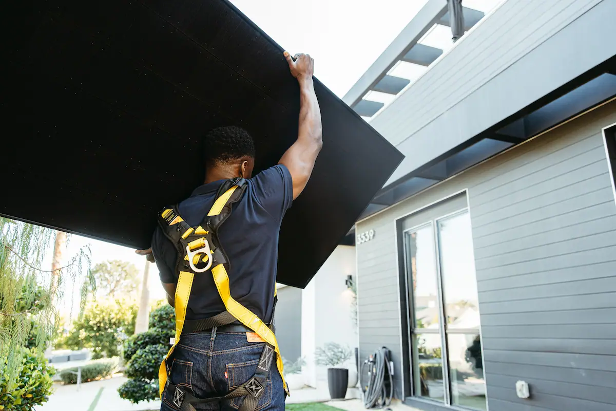 Installer carrying a solar panel