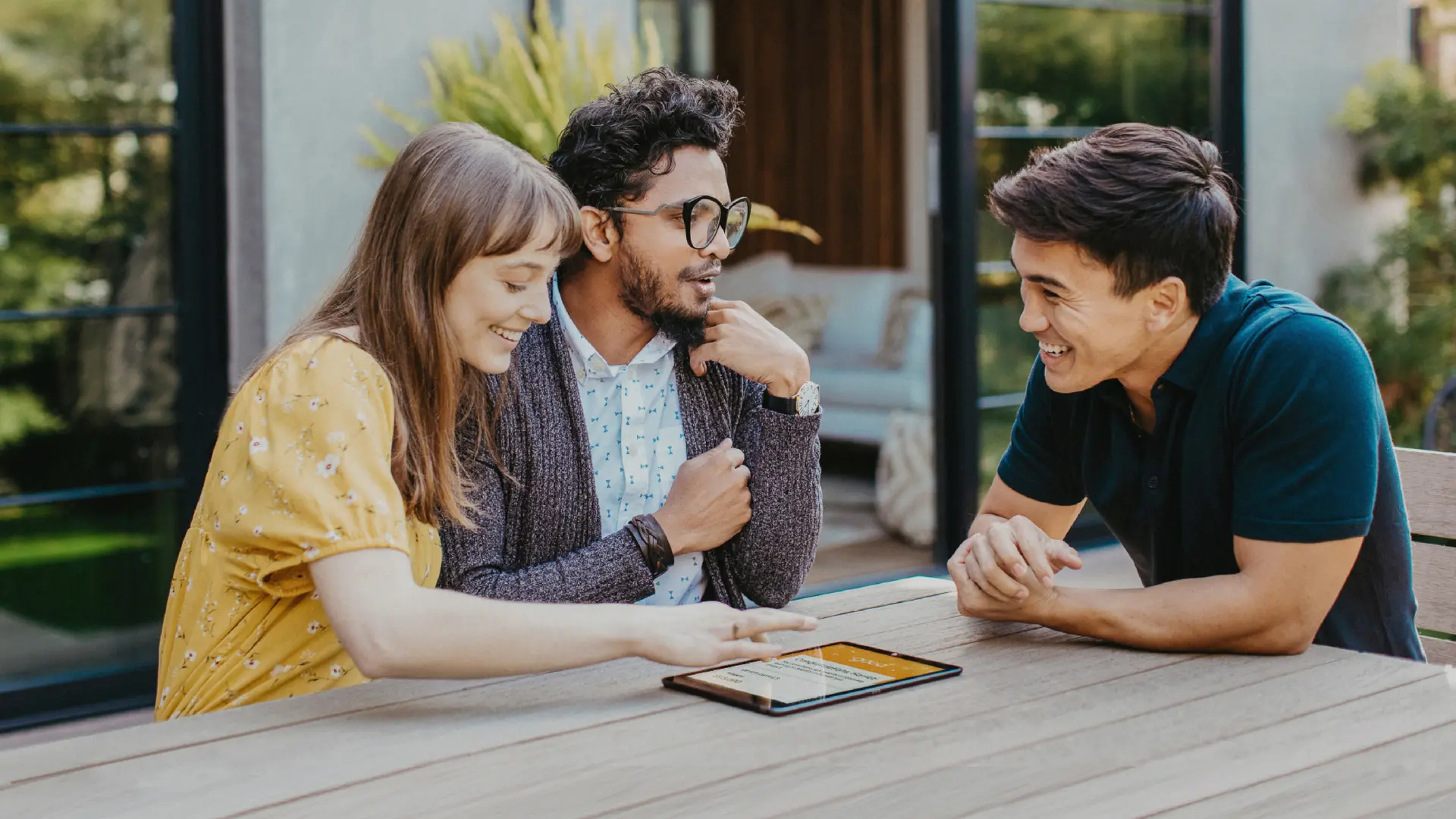 Homeowners sitting at a table outside with a sales rep