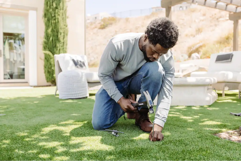 Someone installing turf in the shade